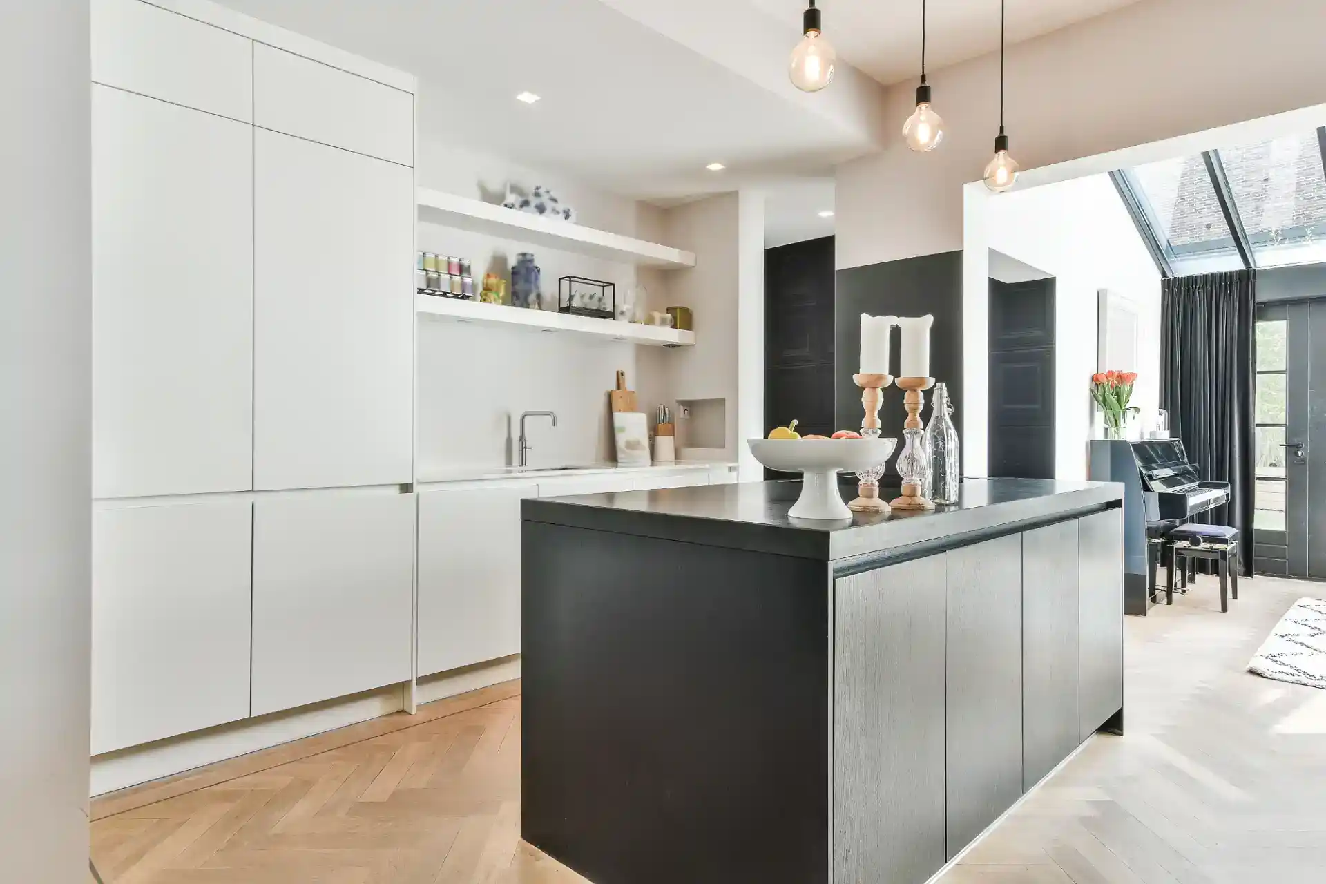 Elegant hvidt og sort køkken med moderne inventar.