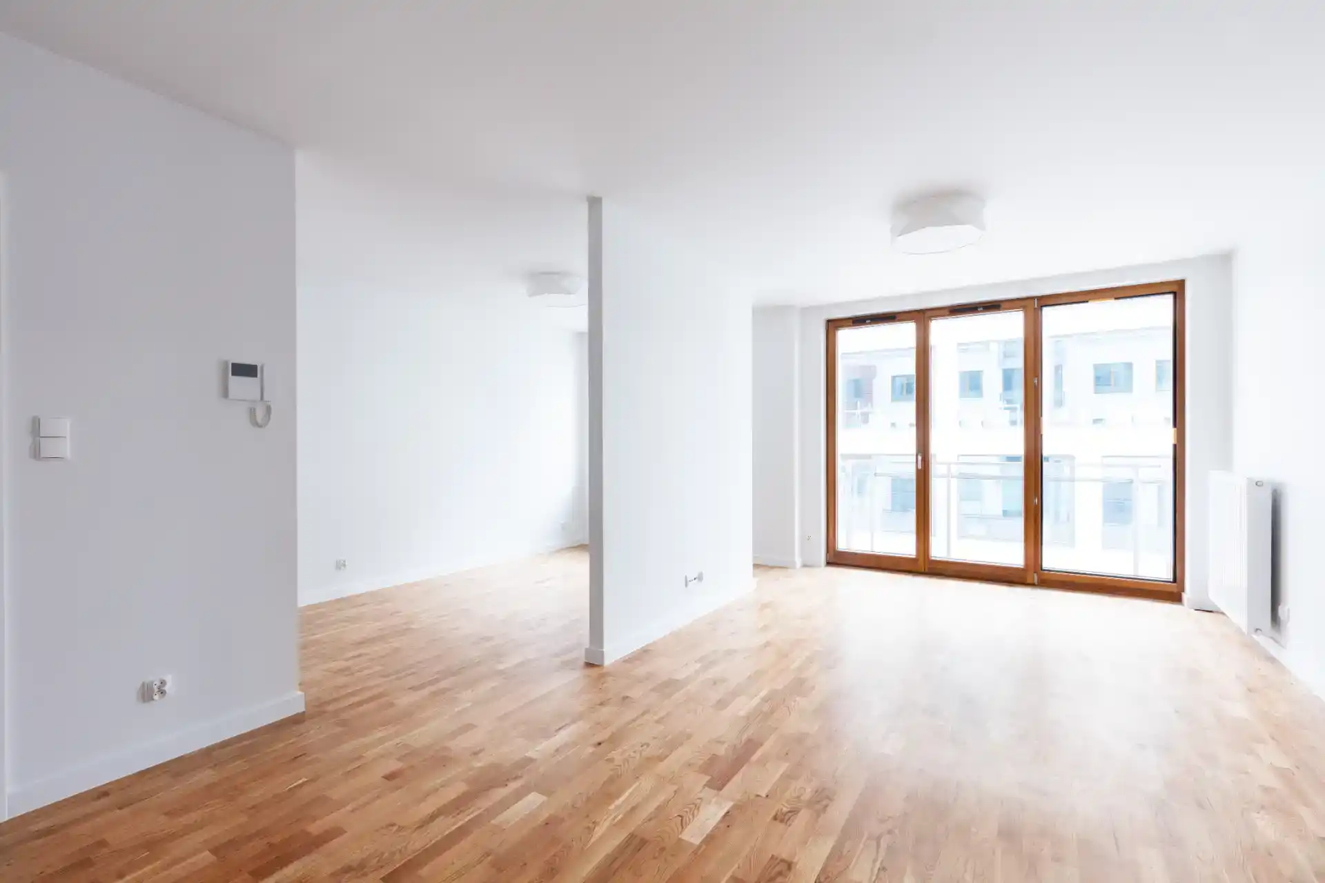 Billede af lys og rummeligt interiør med trægulv, store vinduer og minimalistisk design.